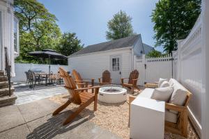 un patio con sedie, un tavolo e un ombrellone di Fairfield Cottage -Top Rated Gem, Fire Pit, Near Beach, 90 Min to NYC a Fairfield