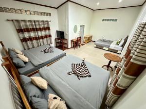 a room with two beds and a living room at บ้านคุณโต้ง เชียงคาน BaanKhunTong ChiangKhan in Chiang Khan