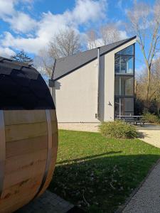 un bâtiment avec un grand tonneau en bois devant lui dans l'établissement B6, à Ursel