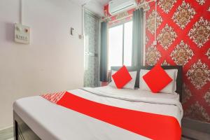 ein rotes und weißes Bett in einem Zimmer mit Fenster in der Unterkunft OYO Oxy Rudra Inn in Ranchi