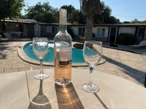 una botella de vino y dos copas de vino en una mesa en Bergerie provençale, en Les Lecques