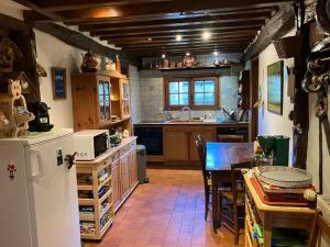 a kitchen with a refrigerator and a table in it at Maison au calme a la campagne in Hermival-les-Vaux