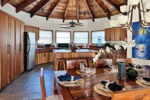 a kitchen with a wooden table and a refrigerator at Villa Serenity in San Pedro