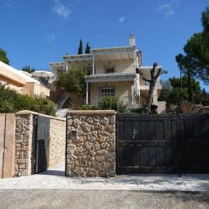 una casa con una puerta negra y una pared de piedra en The Aghios Emilianos Dreamvilla wh infinite pool, en Karafotaíika