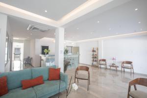 sala de estar con sofá azul y sillas en Pavlinia Hotel & Apartments, en Ayia Napa