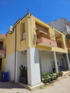 a yellow and white building with a balcony at Apartman Marija in Baška Voda