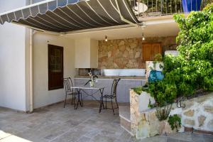 patio ze stołem i krzesłami pod parasolem w obiekcie Petit coin de Paradis a cote de Monaco w mieście Roquebrune-Cap-Martin