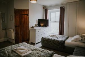 a bedroom with a bed and a tv and a window at Troutbeck Inn in Troutbeck