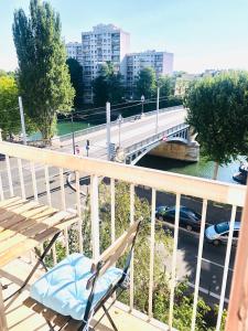 una silla sentada en un balcón con un puente en The FRIENDLY, T5 proche Paris, en Villeneuve-la-Garenne