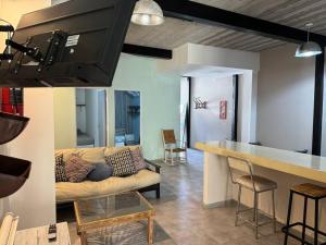 a kitchen and a living room with a couch and a table at ApartHotel Lacatedral in Reconquista