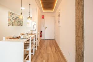 a kitchen with white walls and a wooden floor at CARTAGENAFLATS, Piso Moderno 3 Dormitorios, Cartagena Center in Cartagena
