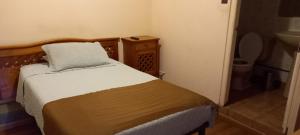 a small bedroom with a bed and a sink at Hostal Viejo Rincon in Antofagasta