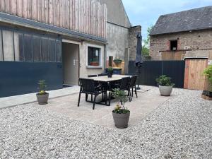 a patio with a table and chairs in a backyard at Maison le ptit chez nous in Pontaubert