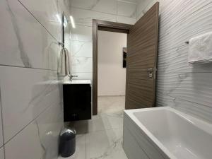 a white bathroom with a tub and a sink at Mediterranean Nest in Is-Swieqi +21 photos