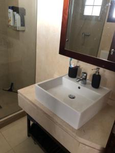 ein Badezimmer mit einem weißen Waschbecken und einem Spiegel in der Unterkunft Pueblo los Monteros in Marbella