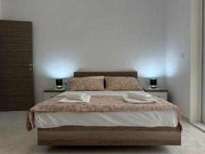 a bedroom with a large bed with two towels on it at Mediterranean Nest in Is-Swieqi