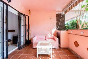 Una sala de estar con un sofá rosa y una mesa. en Apartamento en Marbella Guadalmina primera linea de campo de golf Los Cartujanos, en Marbella 39 fotos más