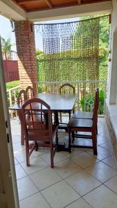 une terrasse couverte avec une table et des chaises. dans l'établissement COLIBRI TAVERNE Gisenyi, à Gisenyi