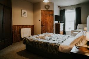 a bedroom with a bed and a chair and a window at Troutbeck Inn in Troutbeck