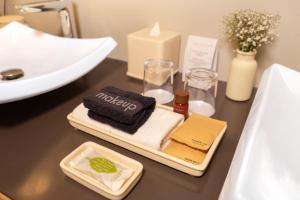 a bathroom counter with a sink and towels and candles at Cartesiano Boutique & Wellness Hotel in Puebla