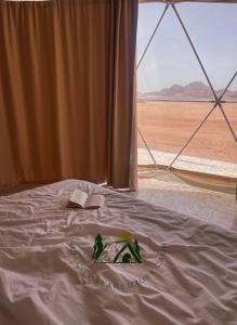 a bedroom with a bed with a window and a book at Rum city Star LUXURY Camp in Wadi Rum
