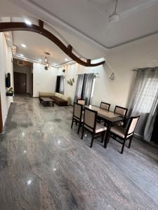a dining room with a table and chairs and a couch at LOFTEL STAYS in Hyderabad