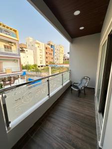 a balcony with a chair and a view of a city at LOFTEL STAYS in Hyderabad