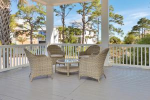 a porch with wicker chairs and a table on it at Brise Del Mar by Pristine Properties Vacation Rentals in Cape San Blas +98 photos
