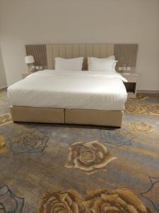 1 dormitorio con 1 cama con una gran colcha blanca en جولدن سيف Golden Sword en Mogayra