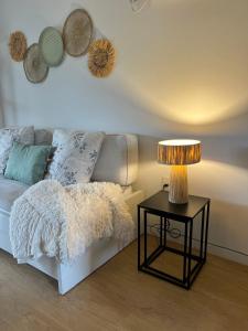 a living room with a couch and a table with a lamp at Puerta Azul in Punta del Este