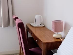 a bedroom with a desk with a lamp and a bed at Little Paradise Marlborough in Marlborough