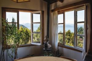 Cette chambre dispose de fenêtres offrant une vue sur les montagnes. dans l'établissement Pajaro Azul, à San Carlos de Bariloche