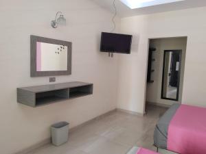 a bedroom with a bed and a tv on the wall at Villa Granada in Santa Cruz Tecamac
