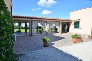 a patio with potted plants in front of a building at La Tenuta del Passero in Le Ferriere