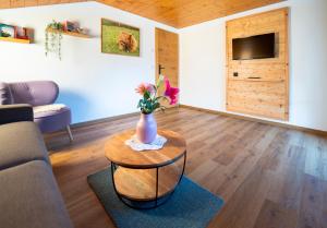 a living room with a vase of flowers on a table at Haus Angelika in Bad Hindelang