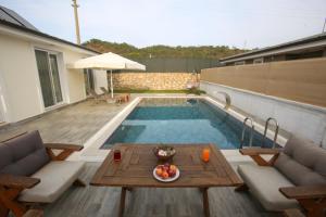 - une piscine avec une table et un bol de fruits dans l'établissement Talia Villalari, à Fethiye