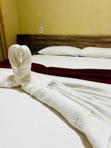 2 camas con toallas blancas encima de ellas en El Dorado Hotel Fortaleza, en Fortaleza