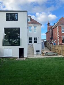 a white house with a picnic table in a yard at Beach House in Swanage