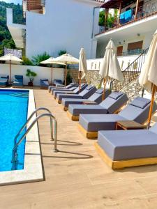 a row of lounge chairs next to a swimming pool at SKIATHOS-FILOKALIA in Achladies