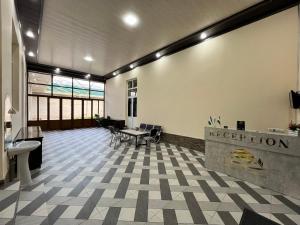 an empty lobby with a reception desk and tables at MrShox Hostel in Samarkand