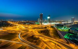 a city skyline at night with traffic on a highway at Atana Hotel in Dubai