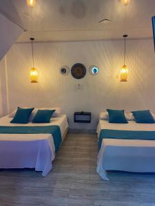 a room with two beds and two lights at Cabaña Aldea Santorini in Doradal