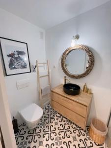 een badkamer met een wastafel, een spiegel en een toilet bij Apartamento Boho Chic in Denia