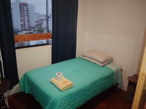Una cama pequeña con un rollo de papel higiénico. en Blue Coast Lima Prívate Rooms en Lima