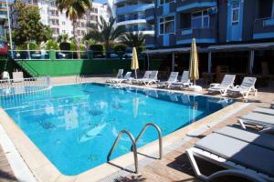 een groot zwembad met stoelen en haaien erin bij Bay Luna Beach hotel in Alanya