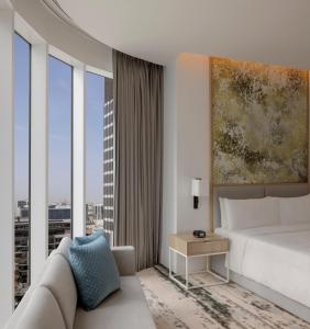 1 dormitorio con cama, sofá y ventanas en Holiday Inn Dubai Business Bay, an IHG Hotel, en Dubái