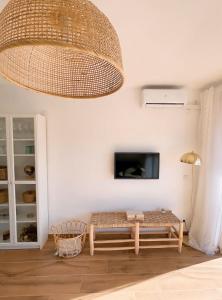 een woonkamer met een tafel en een grote kroonluchter bij Apartamento Boho Chic in Denia