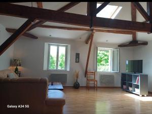 a living room with a couch and two windows at La maison d'Amelie in Montesquieu-Volvestre