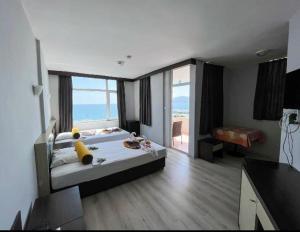 een slaapkamer met een groot bed en een groot raam bij Bay Luna Beach hotel in Alanya