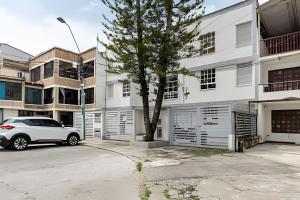 a white car parked in front of a white building at Amplios Apartamentos San Fernando Cerca a Centros Médicos in Cali